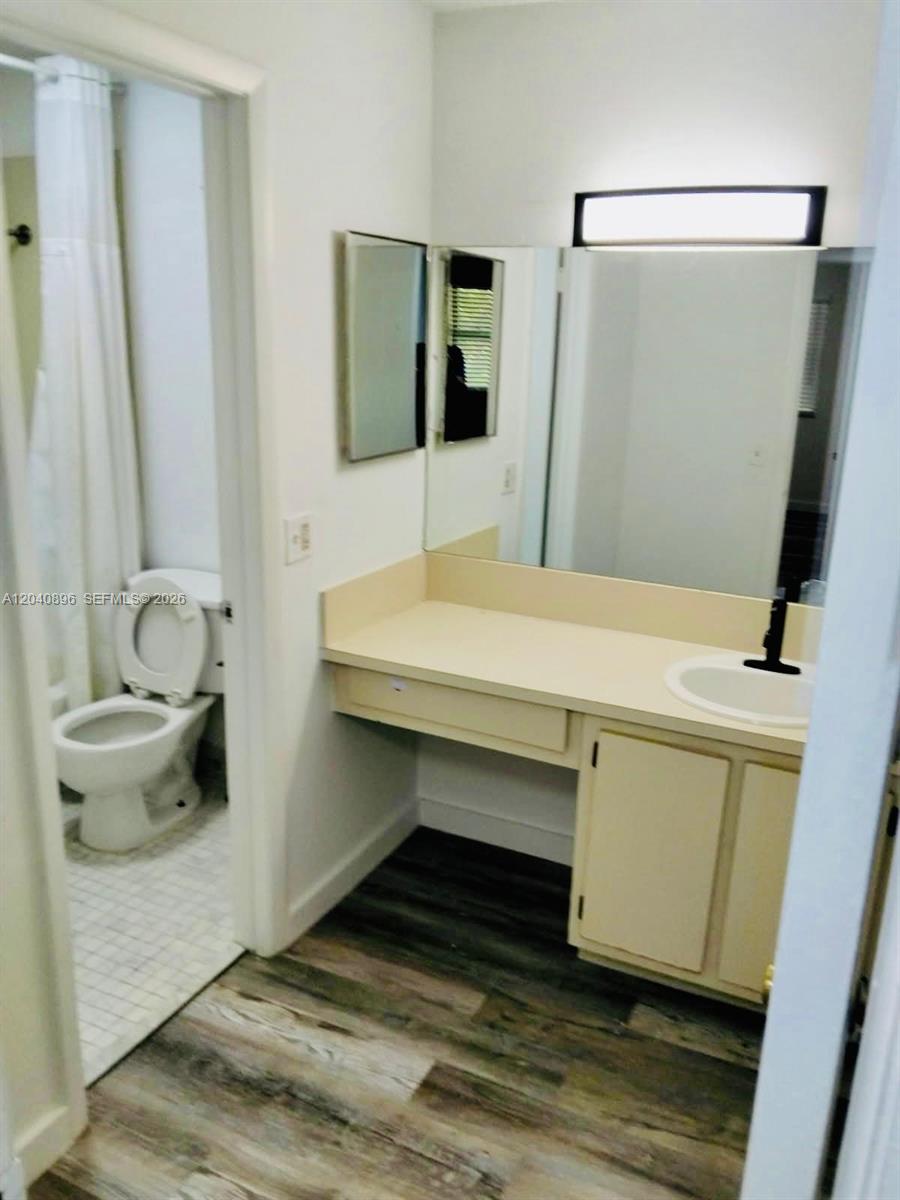 A bathroom features a vanity with a sink, a large mirror, and a separate toilet area — 15530 SW 80th St # 306, Miami FL 33193, MIAMI, FL
