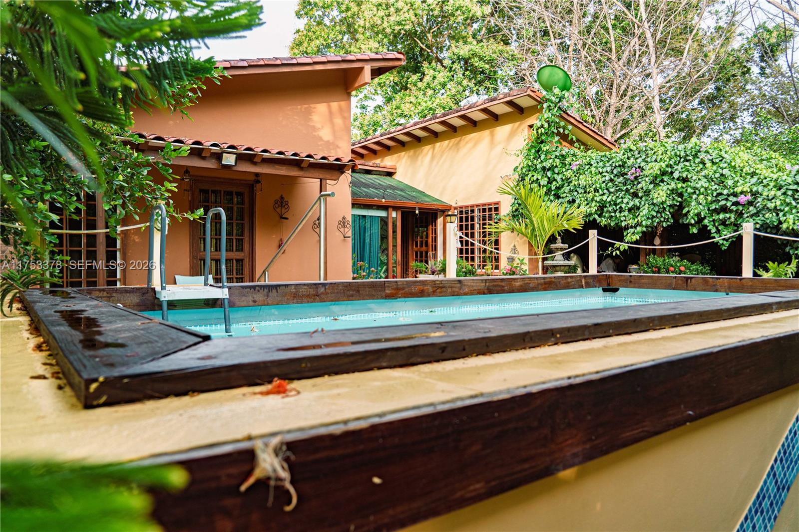 A backyard features an above-ground swimming pool with a wooden deck and a stucco house — San Carlos Panama West Republic of Panama, al, al