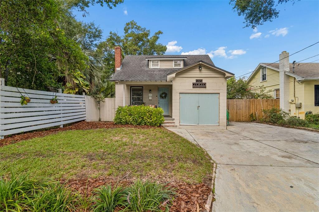 A single-story house with a light-colored facade, a garage, and a white horizontal-slat fence — 2914 N WOODROW AVENUE, TAMPA, FL