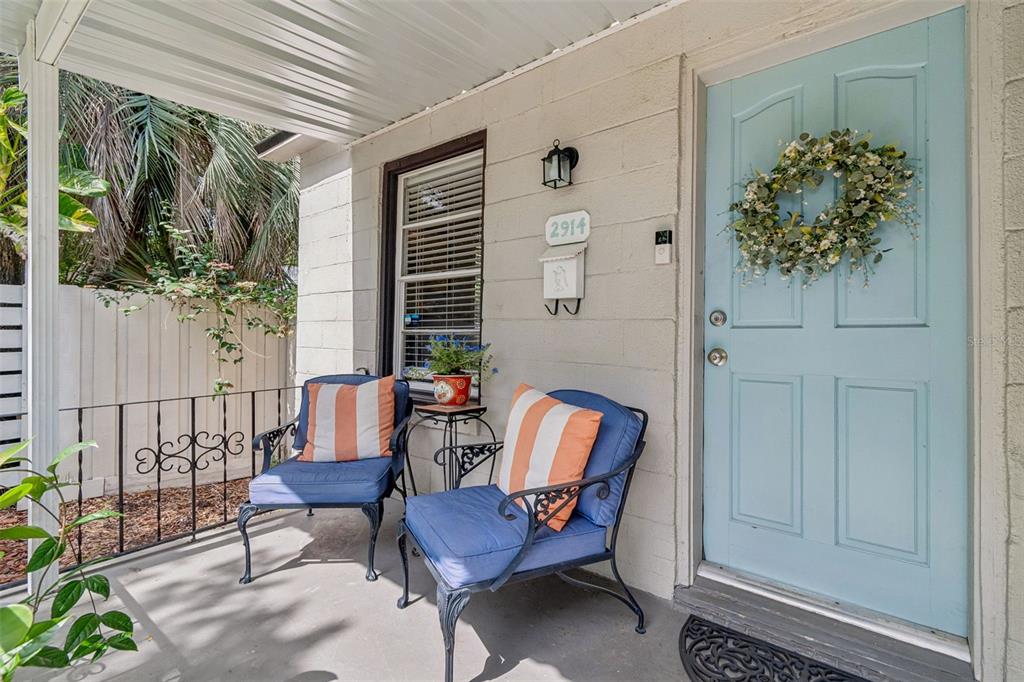 A living room features a sectional sofa, a wooden coffee table, and stairs leading upward — 2914 N WOODROW AVENUE, TAMPA, FL