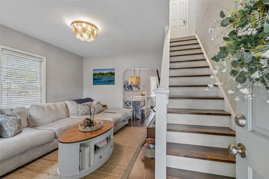 A living room features a large sectional sofa, an oval coffee table, and arched entryway — 2914 N WOODROW AVENUE, TAMPA, FL