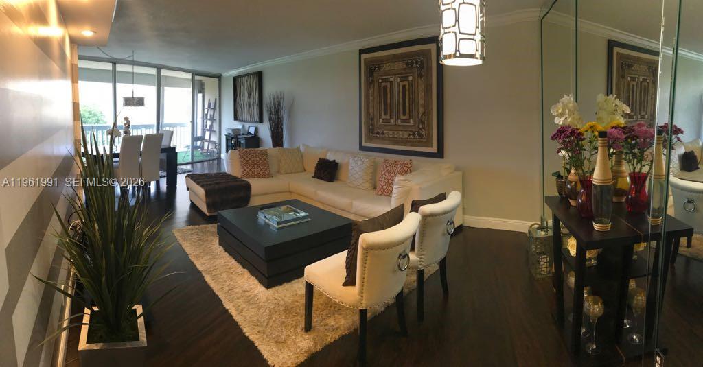 A living room features a white sectional sofa, dark wood floors, and a dining area — 6901 Environ Blvd # 5F, Lauderhill FL 33319, LAUDERHILL, FL