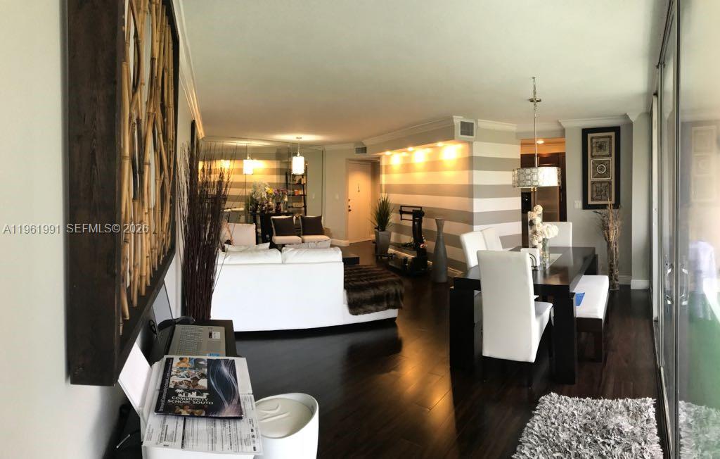 A living and dining area features dark wood floors, striped walls, and a white sofa — 6901 Environ Blvd # 5F, Lauderhill FL 33319, LAUDERHILL, FL