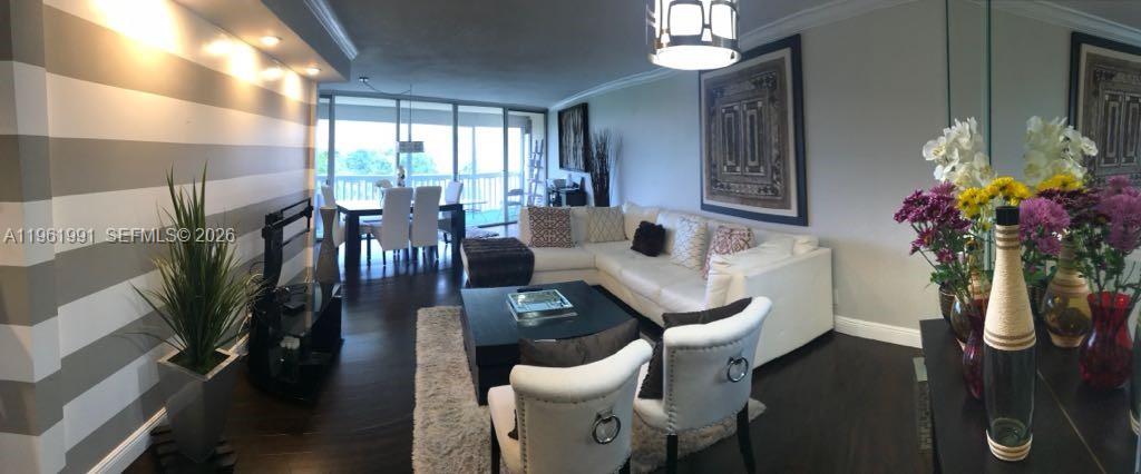 A living room features a white sectional sofa, striped accent wall, and dark hardwood floors — 6901 Environ Blvd # 5F, Lauderhill FL 33319, LAUDERHILL, FL