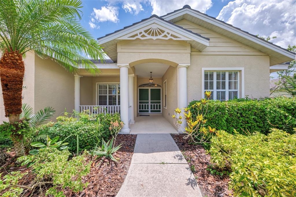 A single-story house with a palm tree, a covered entryway, and a concrete walkway — 6644 BUTLERS CREST DRIVE, BRADENTON, FL