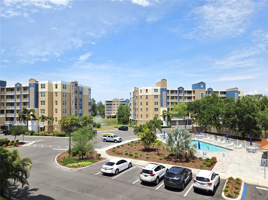 An exterior view of apartment buildings with a parking lot and a swimming pool — 960 STARKEY ROAD UNIT 9206, LARGO, FL