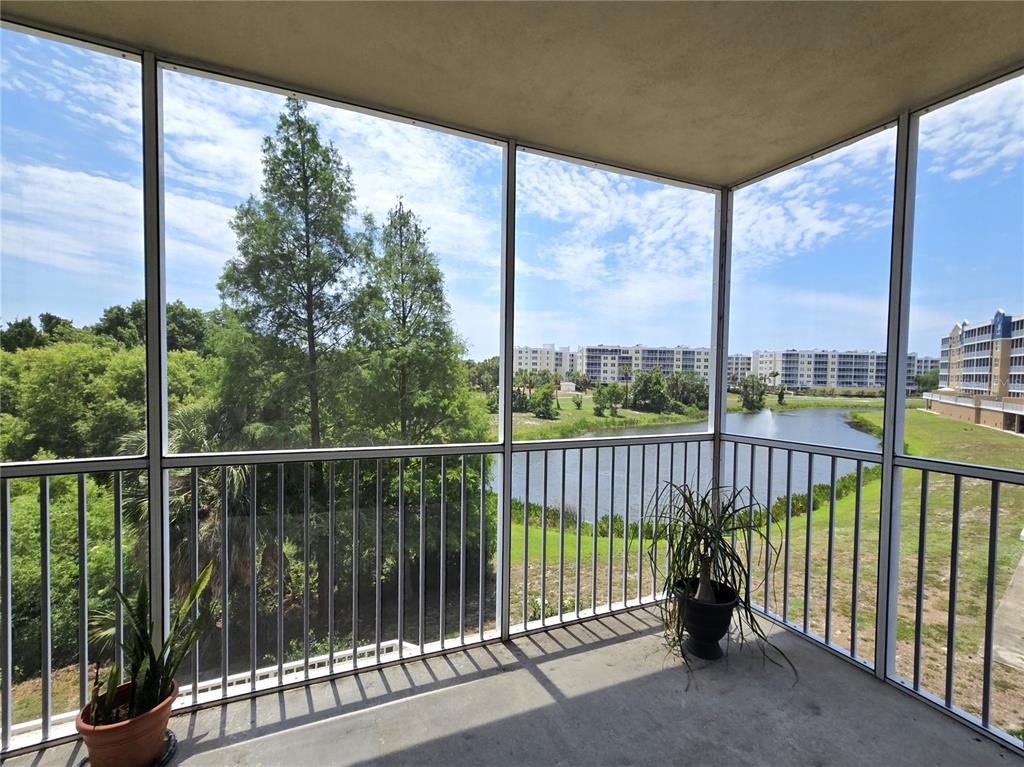 A screened-in balcony overlooks a pond and apartment buildings on a sunny day — 960 STARKEY ROAD UNIT 9206, LARGO, FL