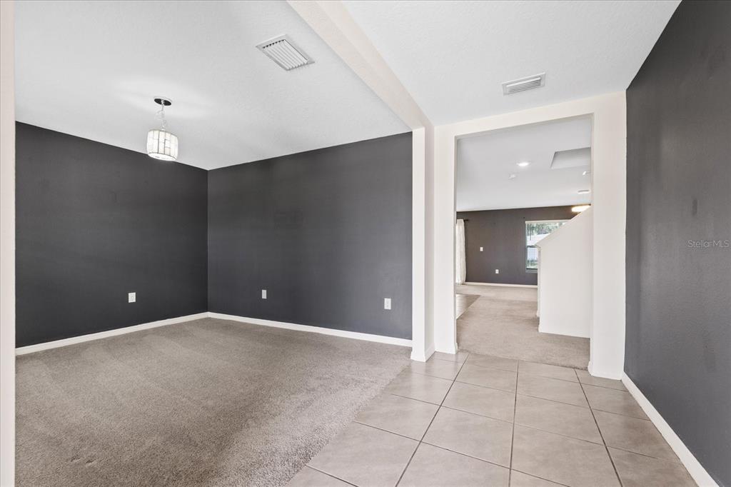A room with dark gray walls, beige carpeting, and a tiled entryway — 13904 WINEBERRY DRIVE, DADE CITY, FL