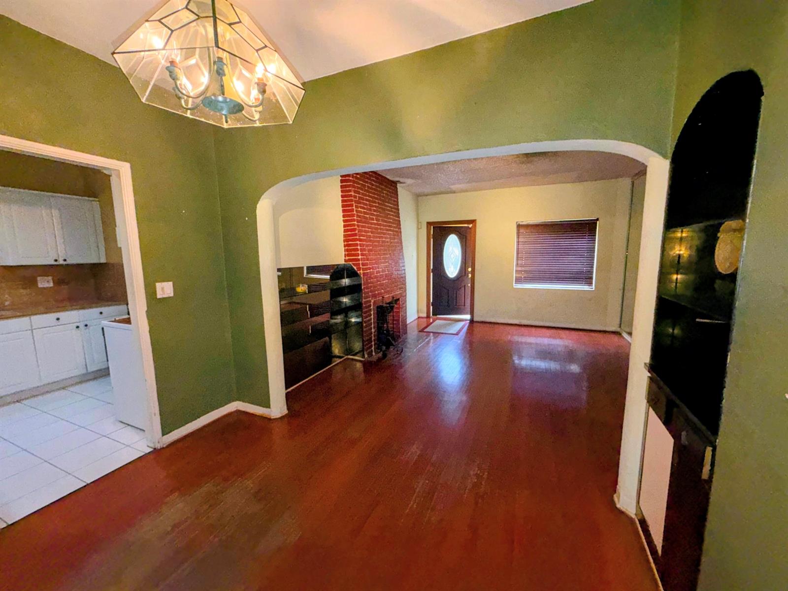 A dining room with green walls and hardwood floors leads into a living area — 424 NE 72nd Street, Miami FL 33138, MIAMI, FL