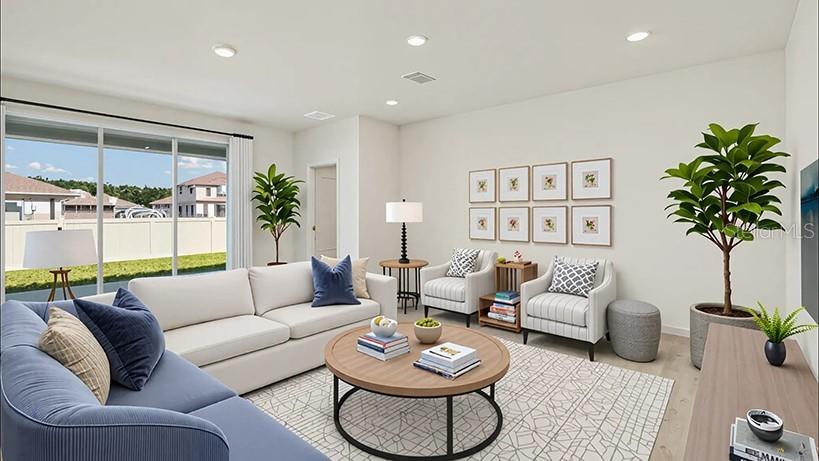 A bright living room features a blue sofa, two armchairs, and a round coffee table — 17035 NW 180TH TERRACE, ALACHUA, FL