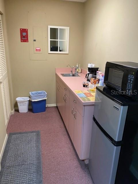 A small kitchenette features pink cabinets, a sink, a microwave, and a mini-fridge — 1531 TAMIAMI TRAIL S UNIT 8A-8T, VENICE, FL