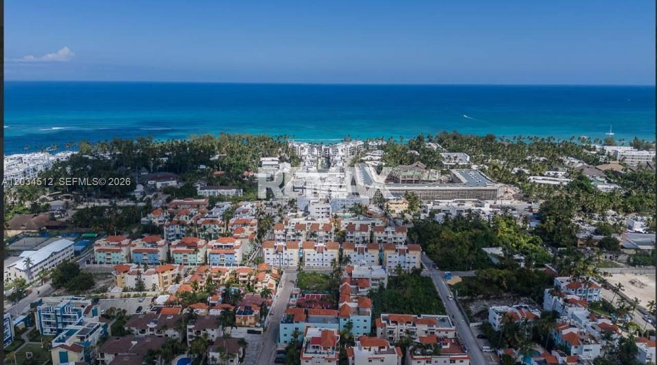 An aerial view shows a coastal town with multi-story apartment buildings near the ocean — 1 El cortecito # 0, FL