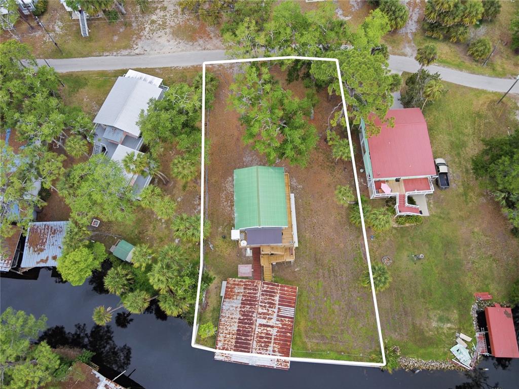 An aerial view shows a house with a green roof on a waterfront lot — 547 SE 205TH STREET, SUWANNEE, FL