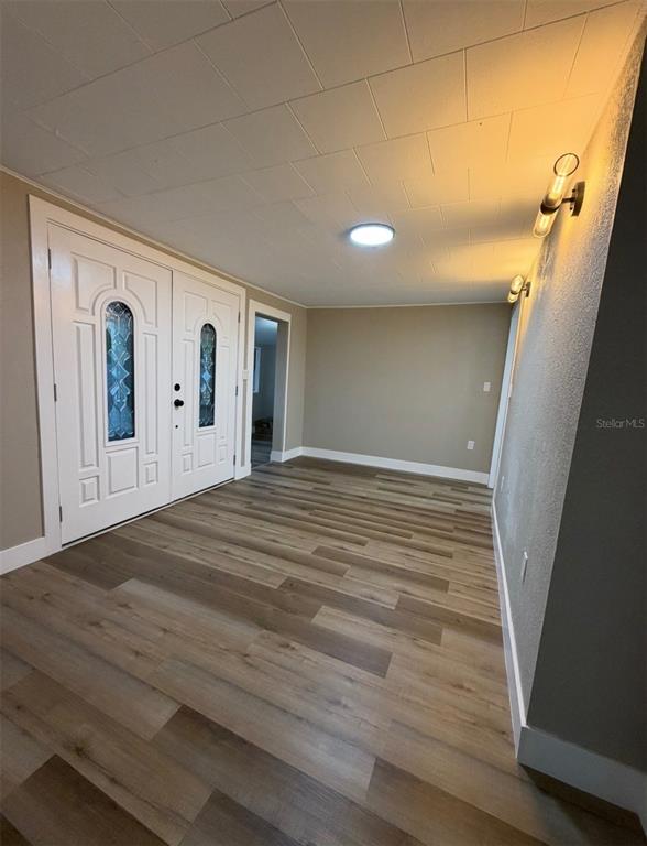 An entryway with double doors, light wood-look flooring, and wall-mounted light fixtures — 1221 E DR MARTIN LUTHER KING JR BOULEVARD, TAMPA, FL