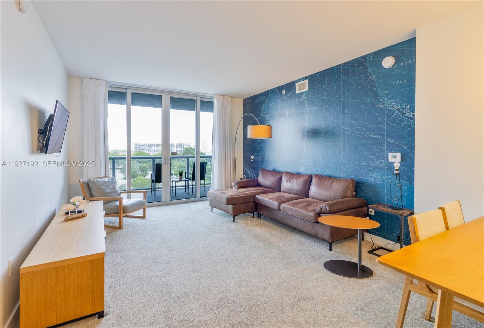 A living room features a brown sectional sofa against a blue map-patterned accent wall — 2602 E Hallandale Beach Blvd # R708, Hallandale Beach FL 33009, HALLANDALE BEACH, FL