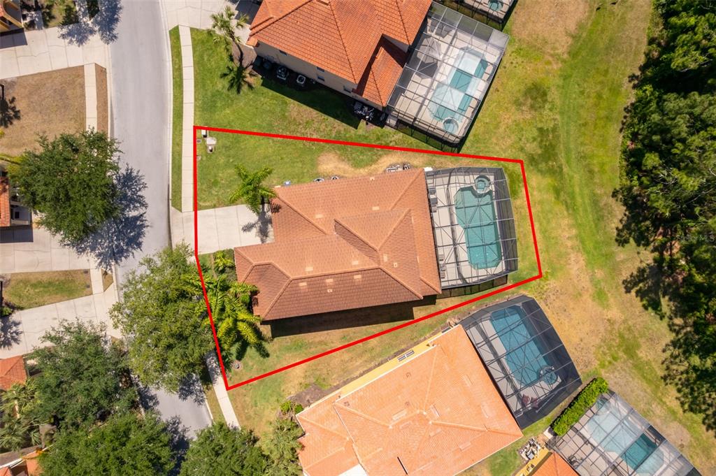 An aerial view shows a house with a tiled roof, a pool cage, and landscaping — 171 ORANGE COSMOS BOULEVARD, DAVENPORT, FL