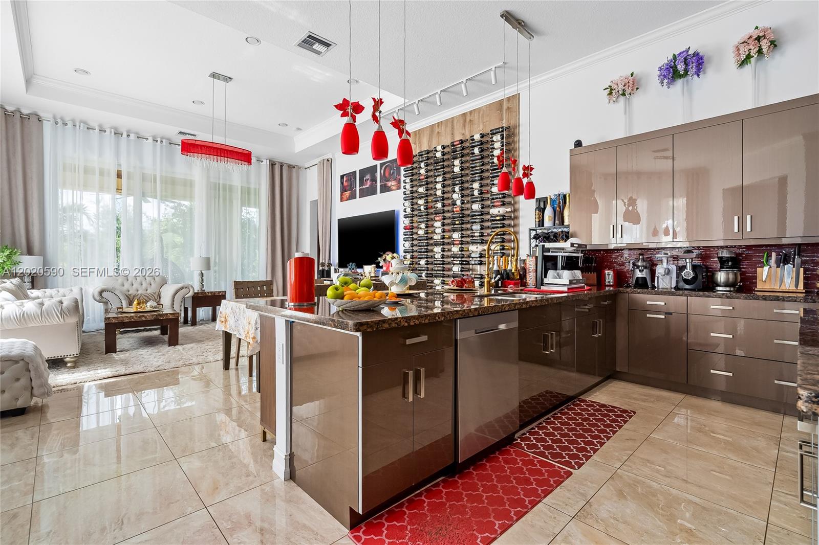 A modern kitchen features glossy brown cabinets, a wine rack wall, and a granite island — 5703 N Sterling Ranch Dr, Davie FL 33314, DAVIE, FL