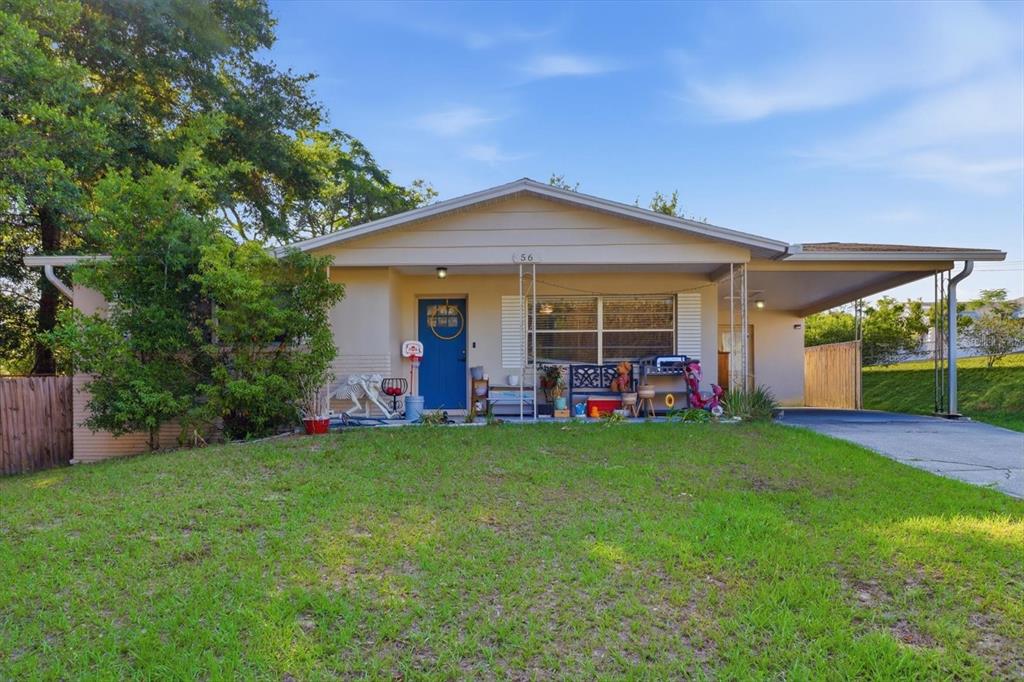 A single-story house with a blue front door, a carport, and a grassy front yard — 56 S COLUMBUS STREET, BEVERLY HILLS, FL