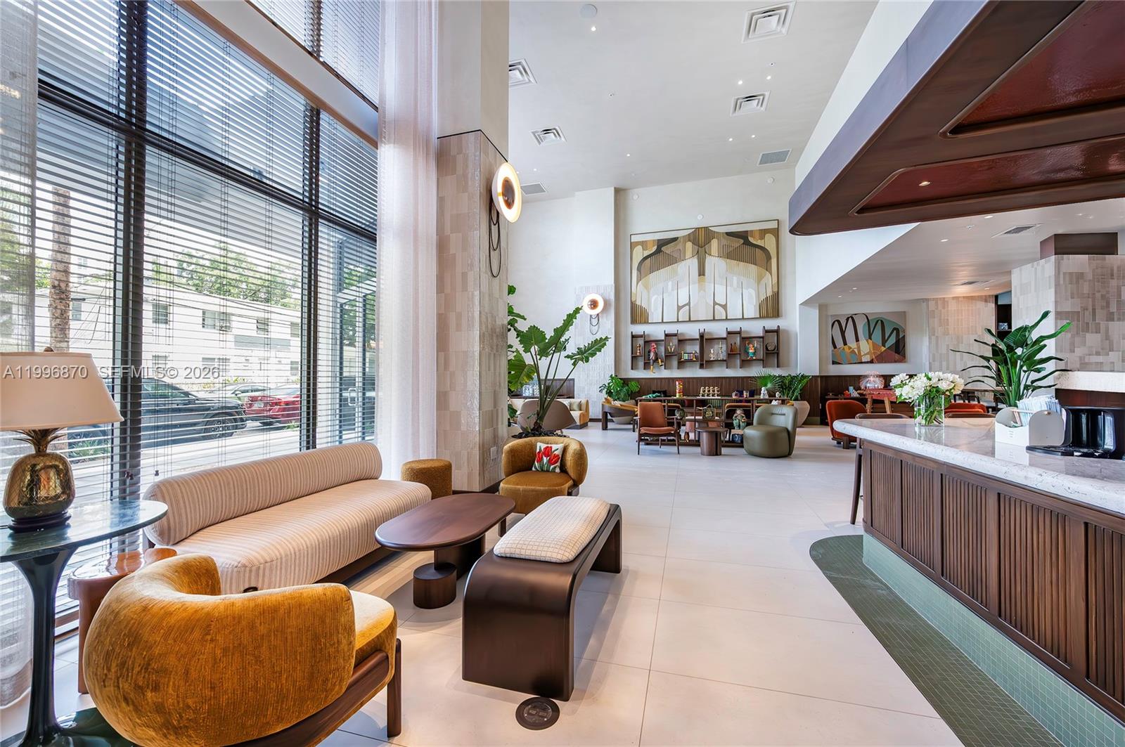 A modern, high-ceilinged lobby features a seating area, a reception desk, and floor-to-ceiling windows — 1611 SW 2nd Ave # 216, Miami FL 33129, MIAMI, FL