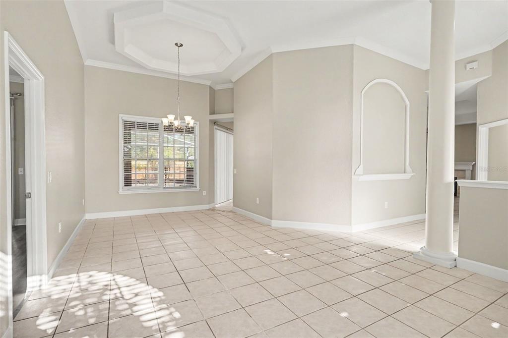 An empty dining room with tile floors, a tray ceiling, and a decorative wall niche — 5535 SUMMERLAND HILLS DRIVE, LAKELAND, FL