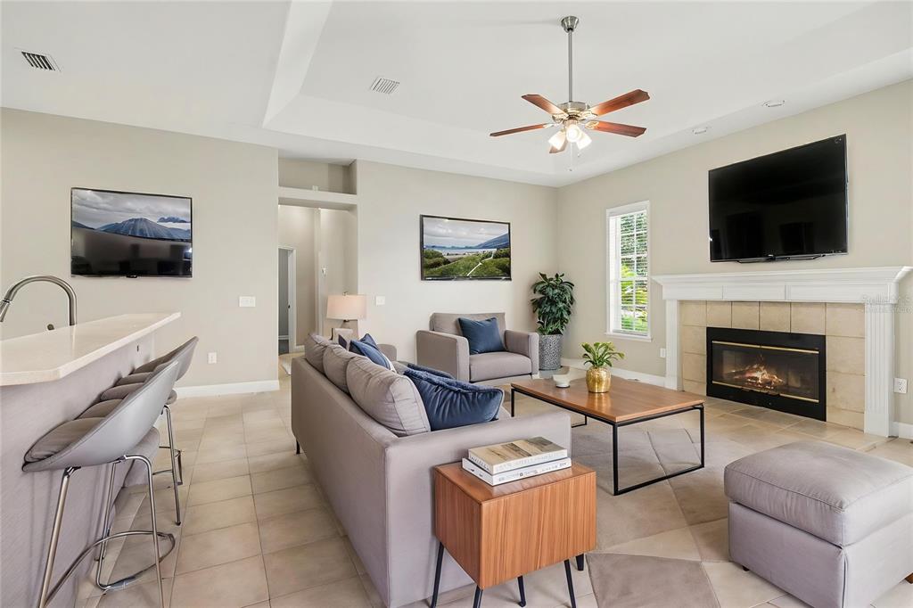 A living room features a fireplace, a sofa, a coffee table, and a breakfast bar — 5535 SUMMERLAND HILLS DRIVE, LAKELAND, FL