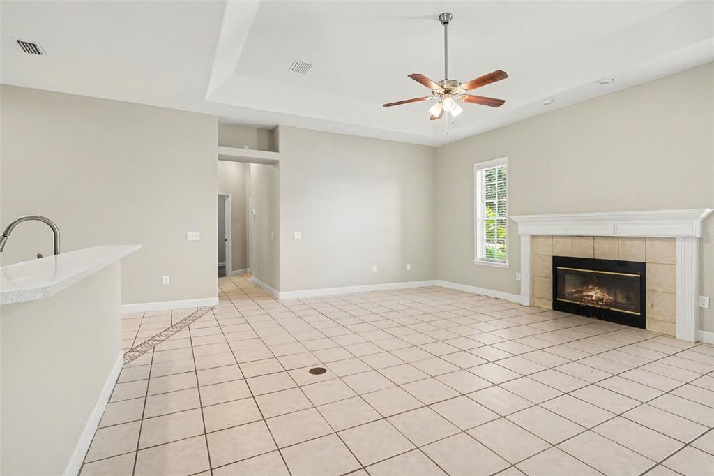 A living room with tile flooring, a fireplace, and a ceiling fan — 5535 SUMMERLAND HILLS DRIVE, LAKELAND, FL