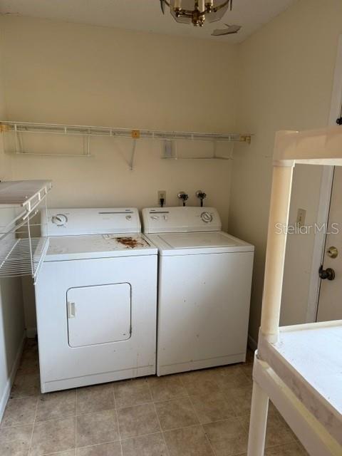 A laundry room features a white washer and dryer beneath a wire shelf — 3048 UNITY TREE DRIVE, EDGEWATER, FL
