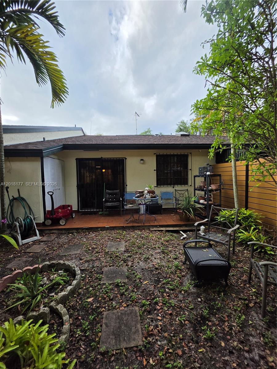 A backyard patio features a tiled floor, outdoor furniture, and a small garden area — 10908 SW 72nd St # 215, Miami FL 33173, MIAMI, FL