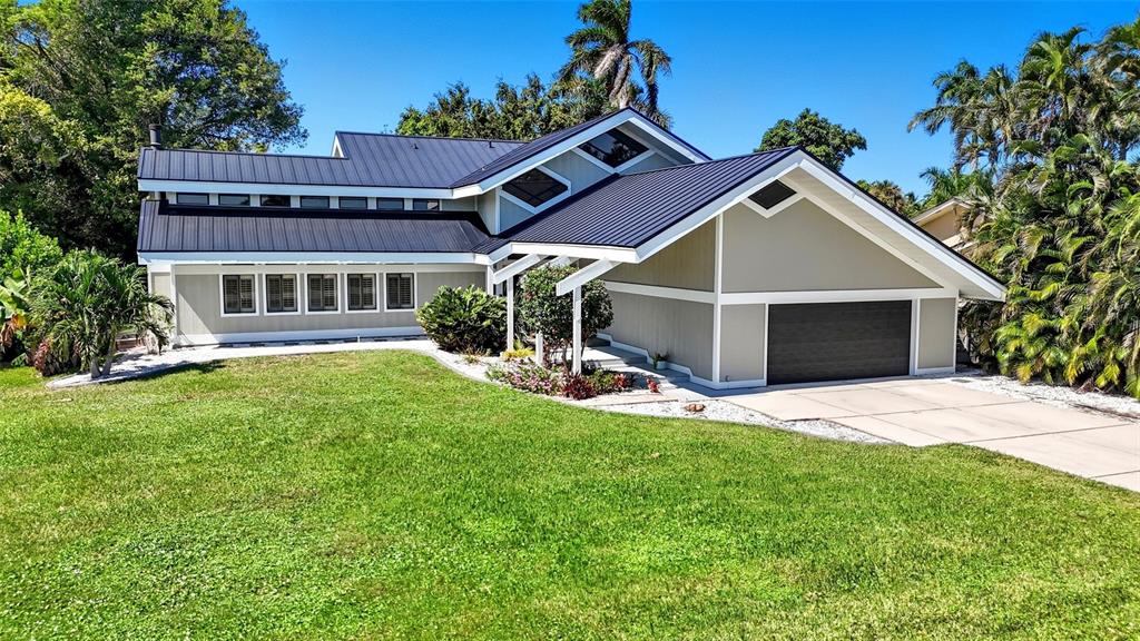 A two-story house with a dark metal roof, light-colored siding, and a two-car garage — 330 PRATHER DRIVE, FORT MYERS, FL
