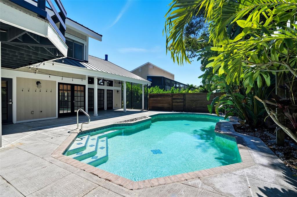 A backyard features a swimming pool with steps next to a house with a patio — 330 PRATHER DRIVE, FORT MYERS, FL