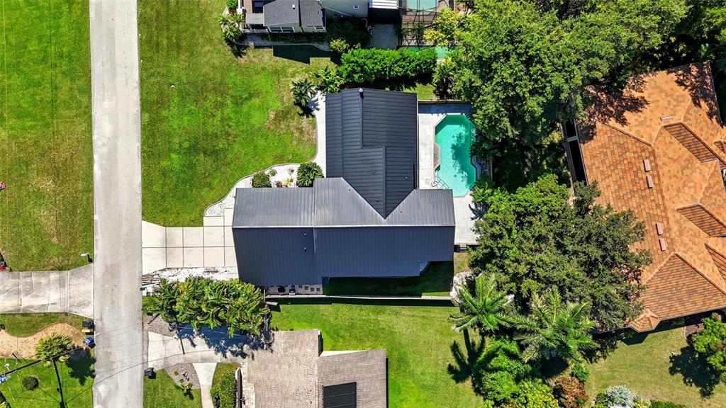 An aerial view shows a house with a dark metal roof and a backyard swimming pool — 330 PRATHER DRIVE, FORT MYERS, FL