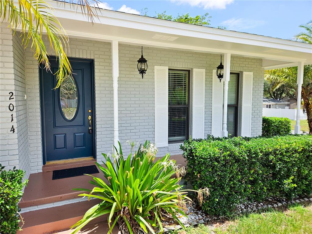 A gray brick house features a dark blue front door and white shutters — 2014 CHARNES DRIVE, LAKELAND, FL