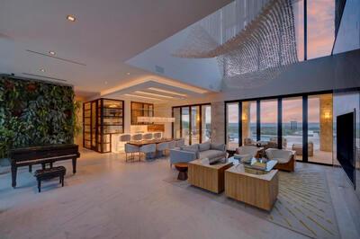 A spacious open-concept living area features a grand piano, a living wall, and floor-to-ceiling windows — VERO BEACH, FL