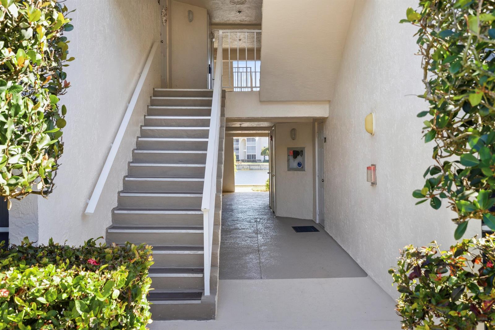 An outdoor staircase leads to an upper level next to a ground-floor walkway — 4452 NE Ocean Blvd # C3, Jensen Beach FL 34957, JENSEN BEACH, FL