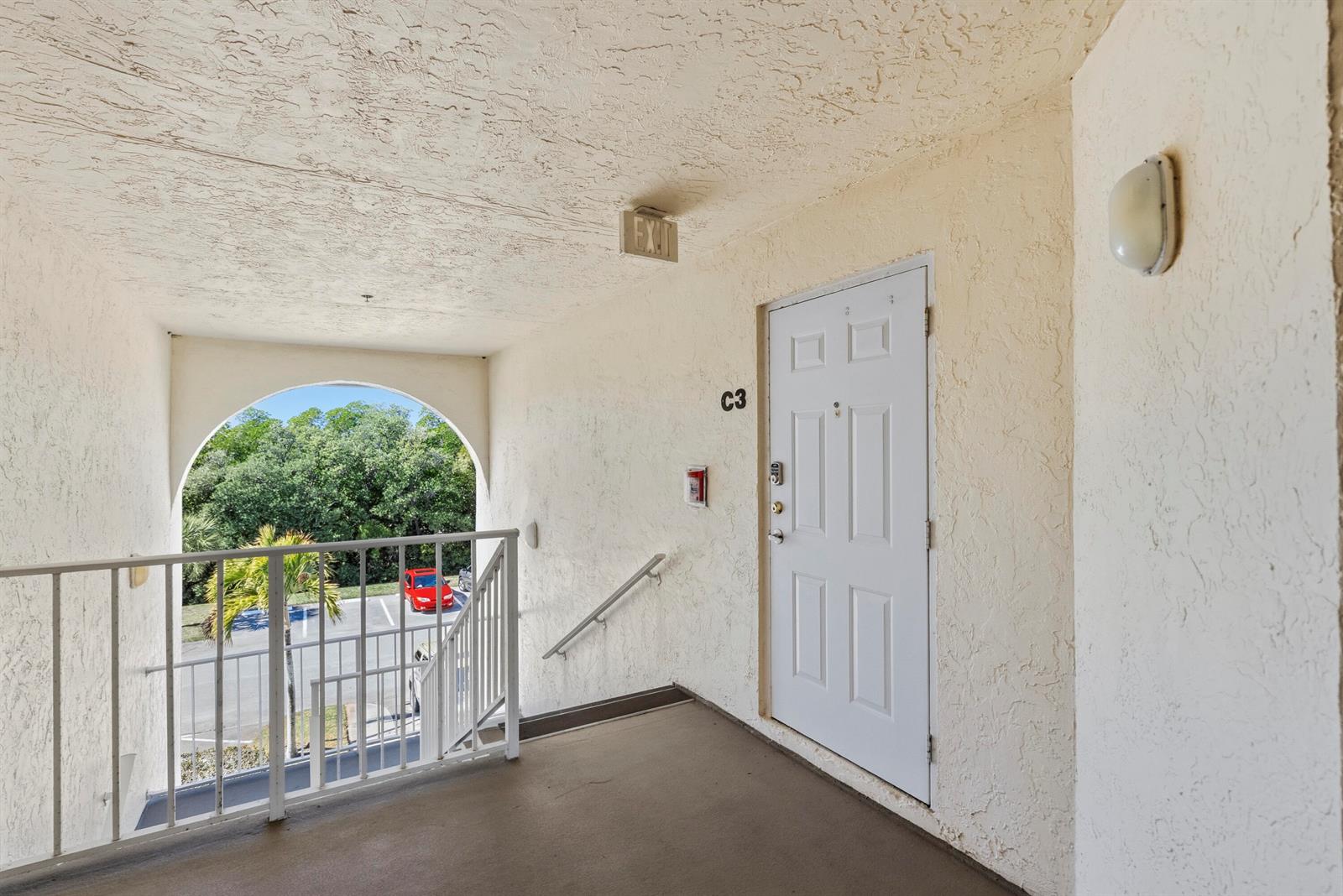 An exterior apartment hallway features a white door labeled C3, a railing, and stairs — 4452 NE Ocean Blvd # C3, Jensen Beach FL 34957, JENSEN BEACH, FL