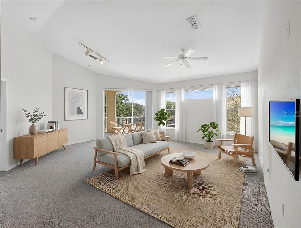 A living room features a grey sofa, wooden coffee table, and a balcony view — 1100 LAKE SHADOW CIRCLE UNIT 2307, MAITLAND, FL