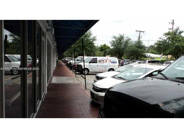 A brick walkway runs alongside a building exterior with parked cars in a parking lot — 1779 SW 3 RD AVE, Miami FL 33129, MIAMI, FL