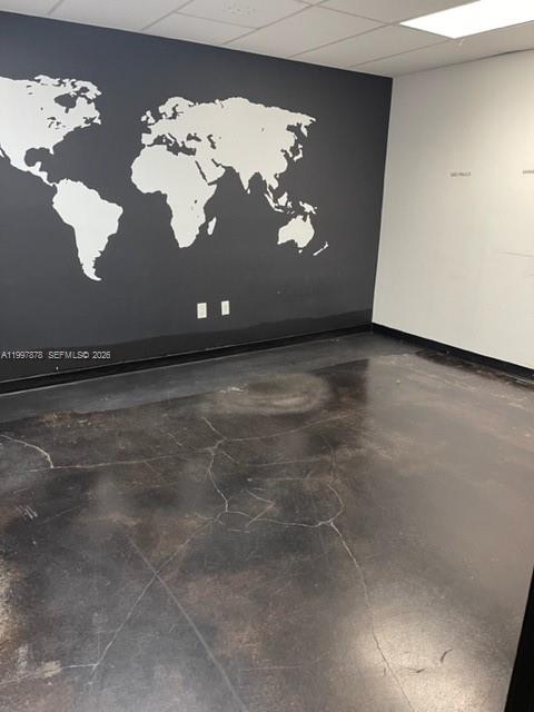 An empty office room features a dark accent wall with a white world map mural — 1779 SW 3 RD AVE, Miami FL 33129, MIAMI, FL