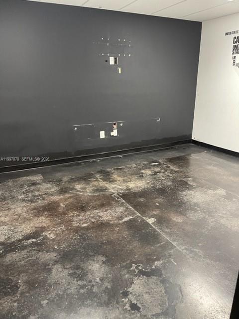 An empty room features a dark accent wall with electrical outlets and a stained concrete floor — 1779 SW 3 RD AVE, Miami FL 33129, MIAMI, FL