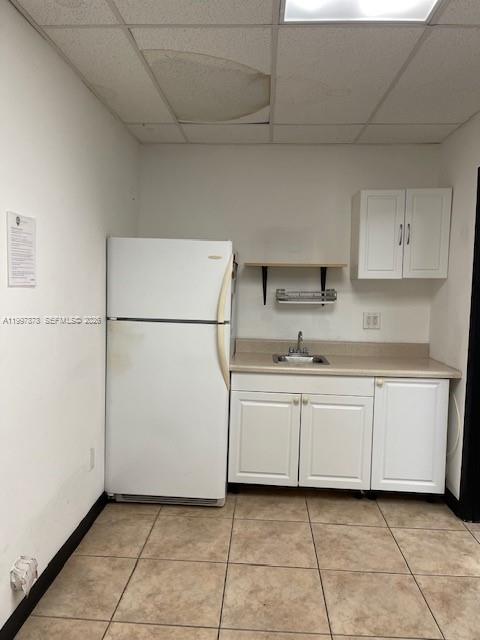 A small kitchen area features a white refrigerator, base cabinets, wall cabinets, and a sink — 1779 SW 3 RD AVE, Miami FL 33129, MIAMI, FL