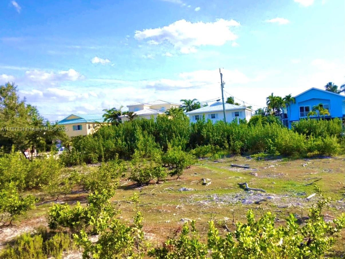 A vacant, grassy lot with scattered shrubs sits in front of several residential houses — 0 Santa Barbara, Marathon FL 33050, MARATHON, FL