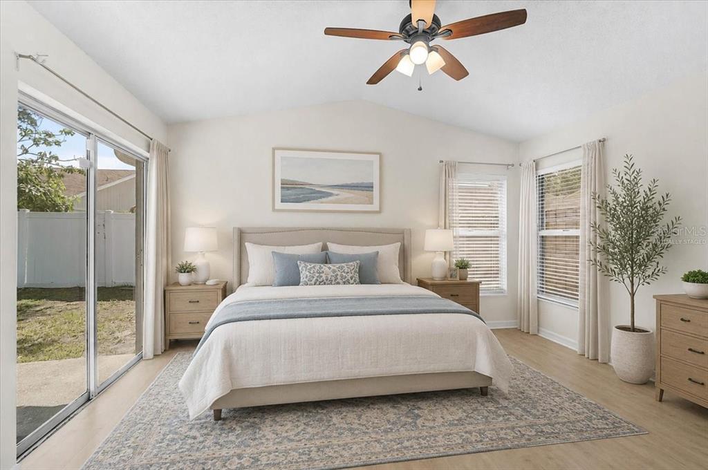 A bedroom features a bed, two nightstands, a ceiling fan, and sliding glass doors — 13616 LARAWAY DRIVE, RIVERVIEW, FL