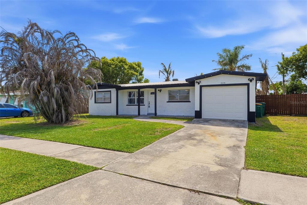A single-story white house with a black-trimmed garage and a concrete driveway — 524 WESTMINSTER AVENUE, MELBOURNE, FL