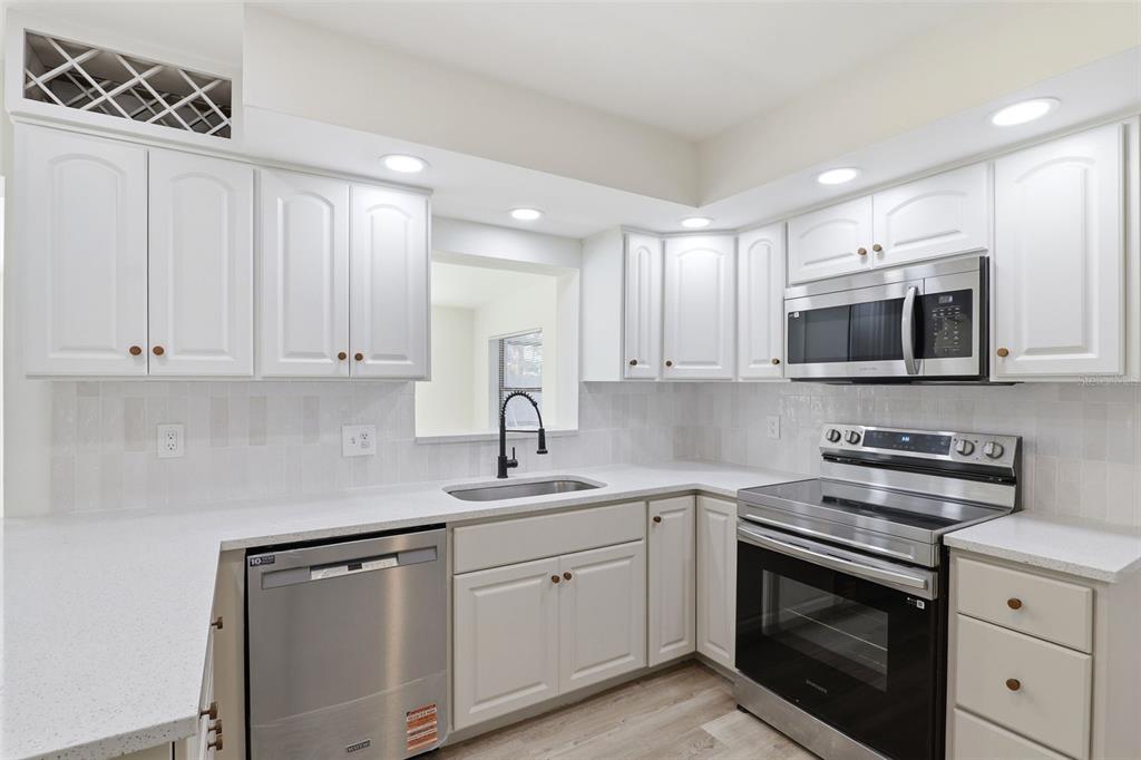 A kitchen with white cabinets, stainless steel appliances, and light countertops — 524 WESTMINSTER AVENUE, MELBOURNE, FL