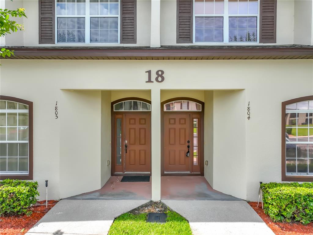 The exterior of a two-story townhouse features two brown front doors with arched windows — 600 NORTHERN WAY UNIT 1804, WINTER SPRINGS, FL