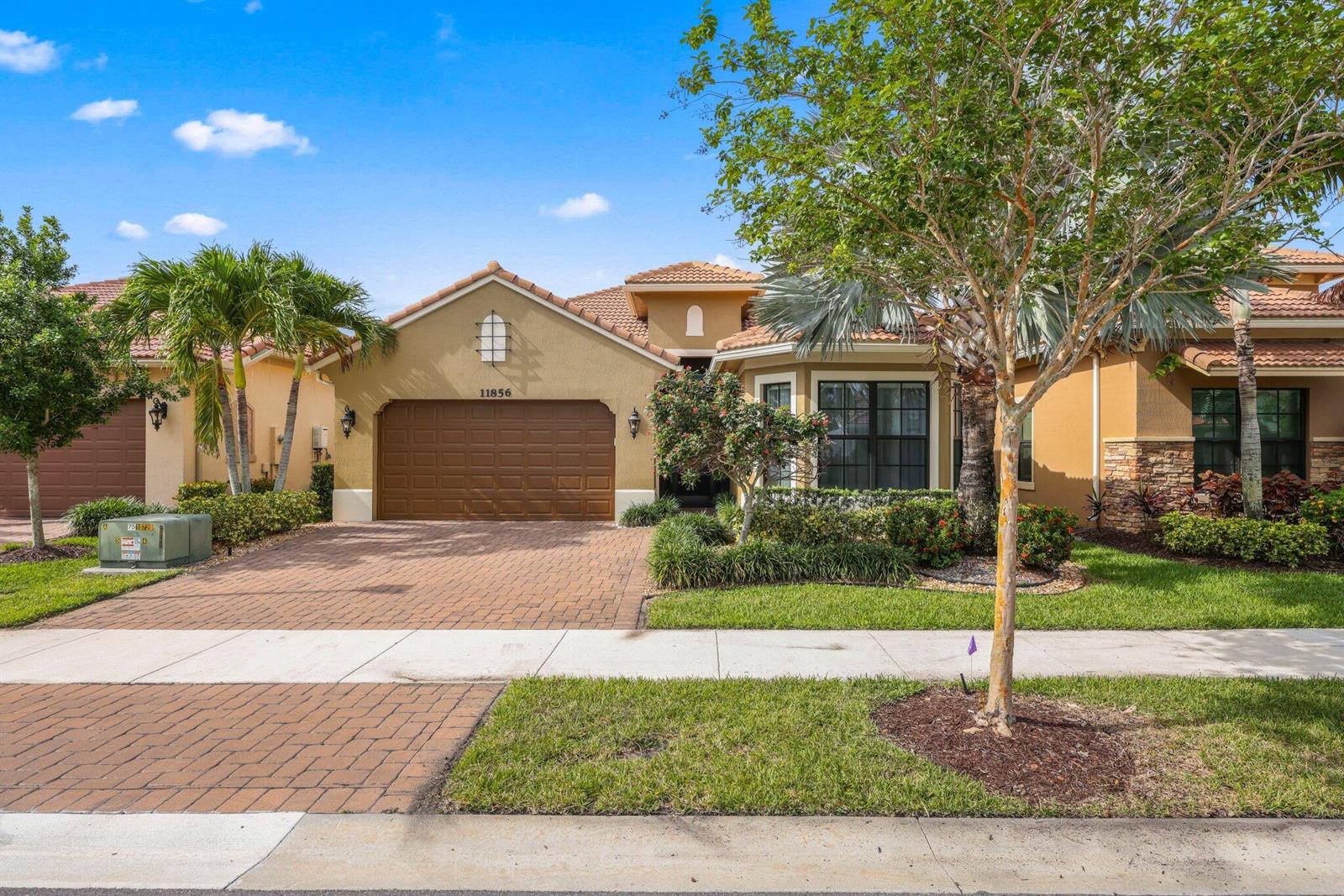 A single-story house with a brown garage, tan stucco walls, and a paved driveway — 11856 Leon Circle N, Parkland FL 33076, PARKLAND, FL