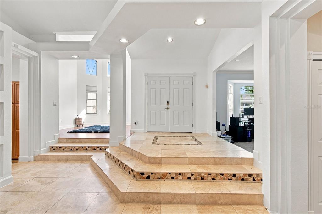 A foyer with light-colored tile flooring, a raised entryway, and double front doors — 13711 DORNOCH DRIVE, ORLANDO, FL
