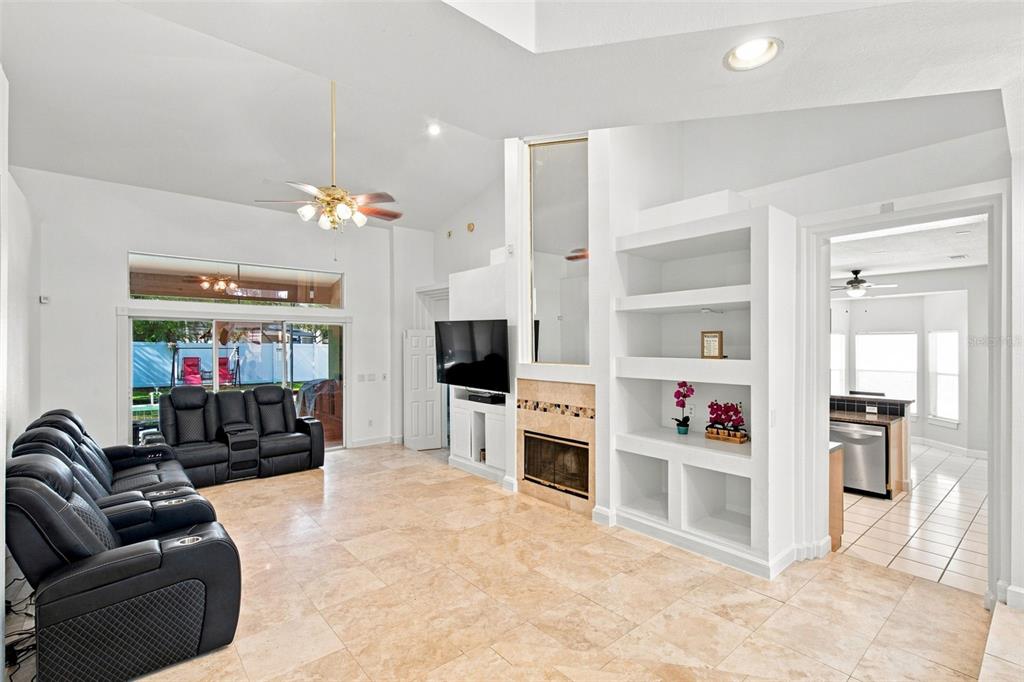 A living room features tile floors, a fireplace, built-in shelving, and a black leather sofa — 13711 DORNOCH DRIVE, ORLANDO, FL