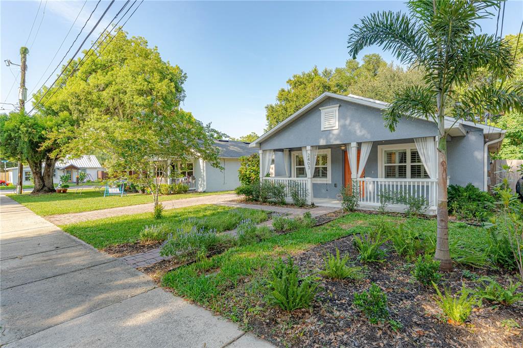 A gray bungalow with a white front porch and a palm tree in the front yard — 2403 MAYER STREET, ORLANDO, FL