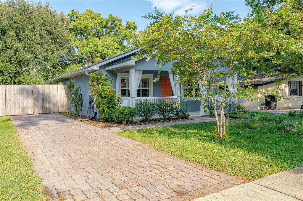 A blue house with a front porch, a brick driveway, and a wooden fence — 2403 MAYER STREET, ORLANDO, FL